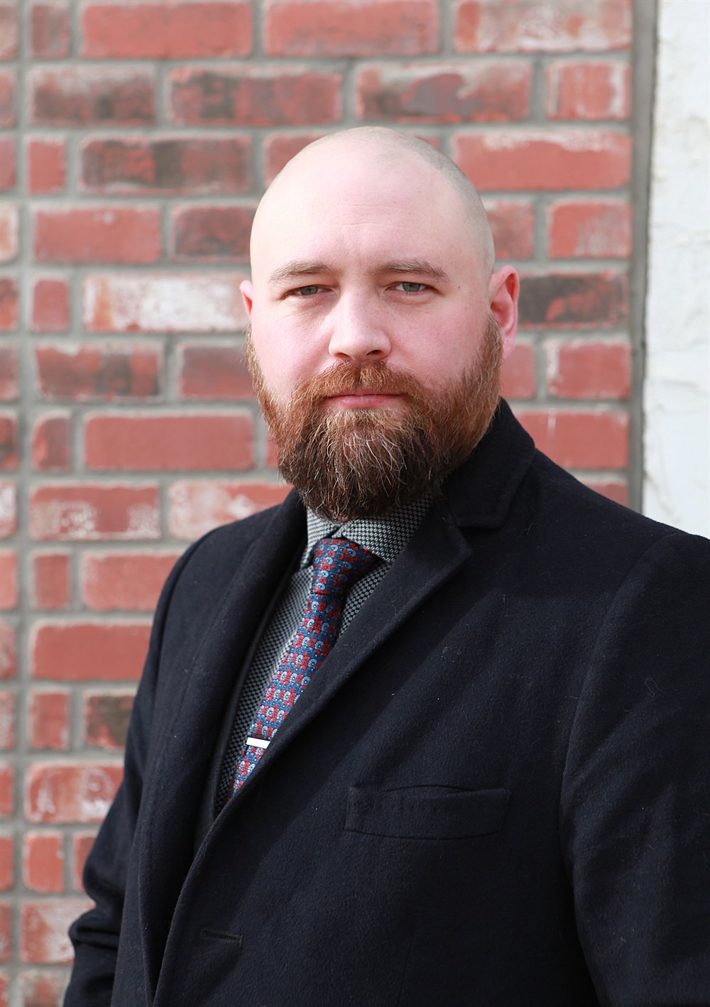 TJ Schmidt in a dark coat and tie