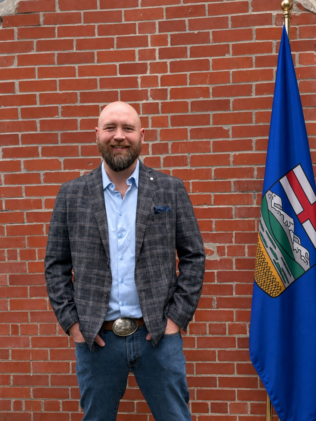 TJ Schmidt standing beside the Alberta flag