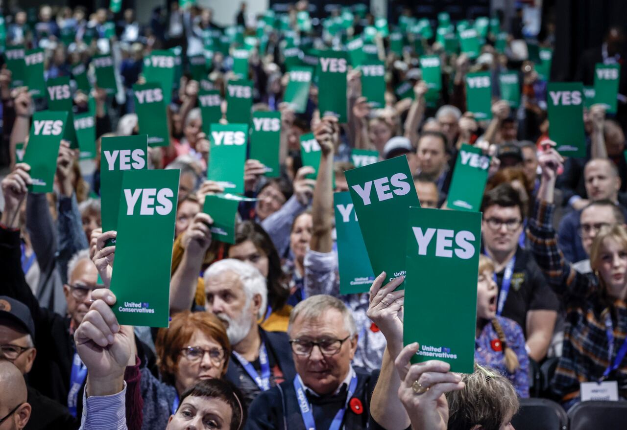 Members raising green YES voting cards at the last UCP AGM